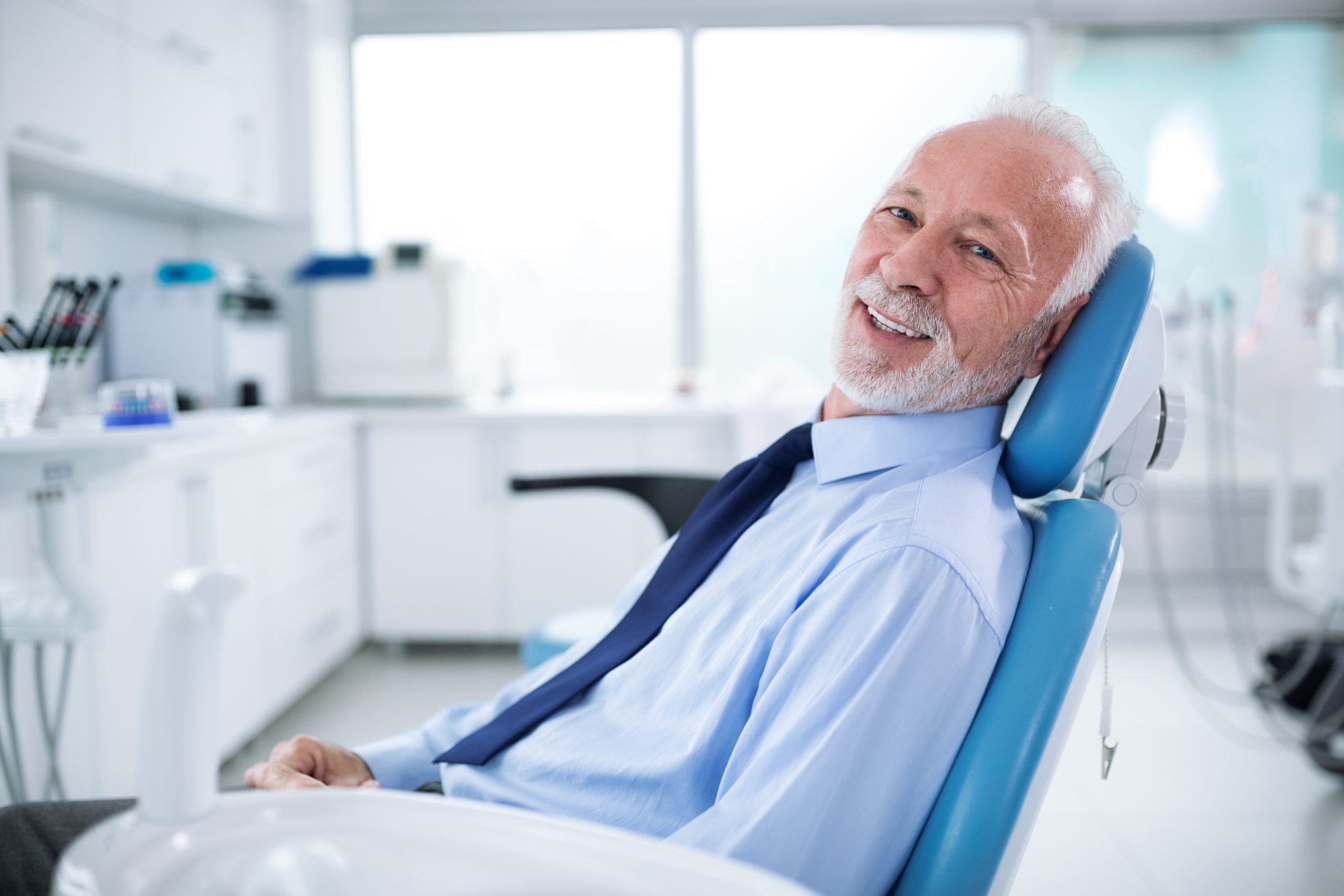 Elderly man in dentist's chair without fear waiting for treatment of their teeth