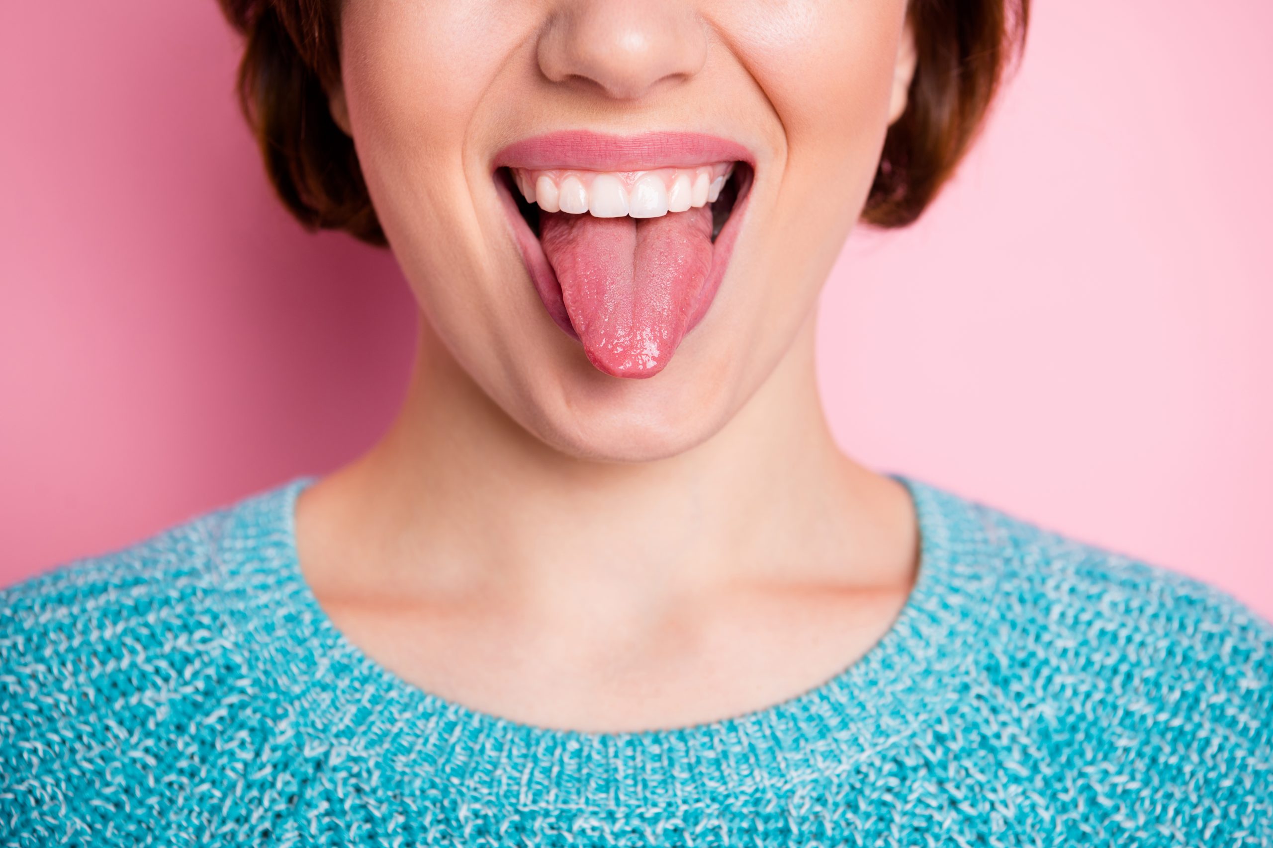 Cropped close-up view portrait of her she nice attractive crazy cheerful cheery, woman showing tongue grimacing healthy oral cavity isolated over pink pastel color background