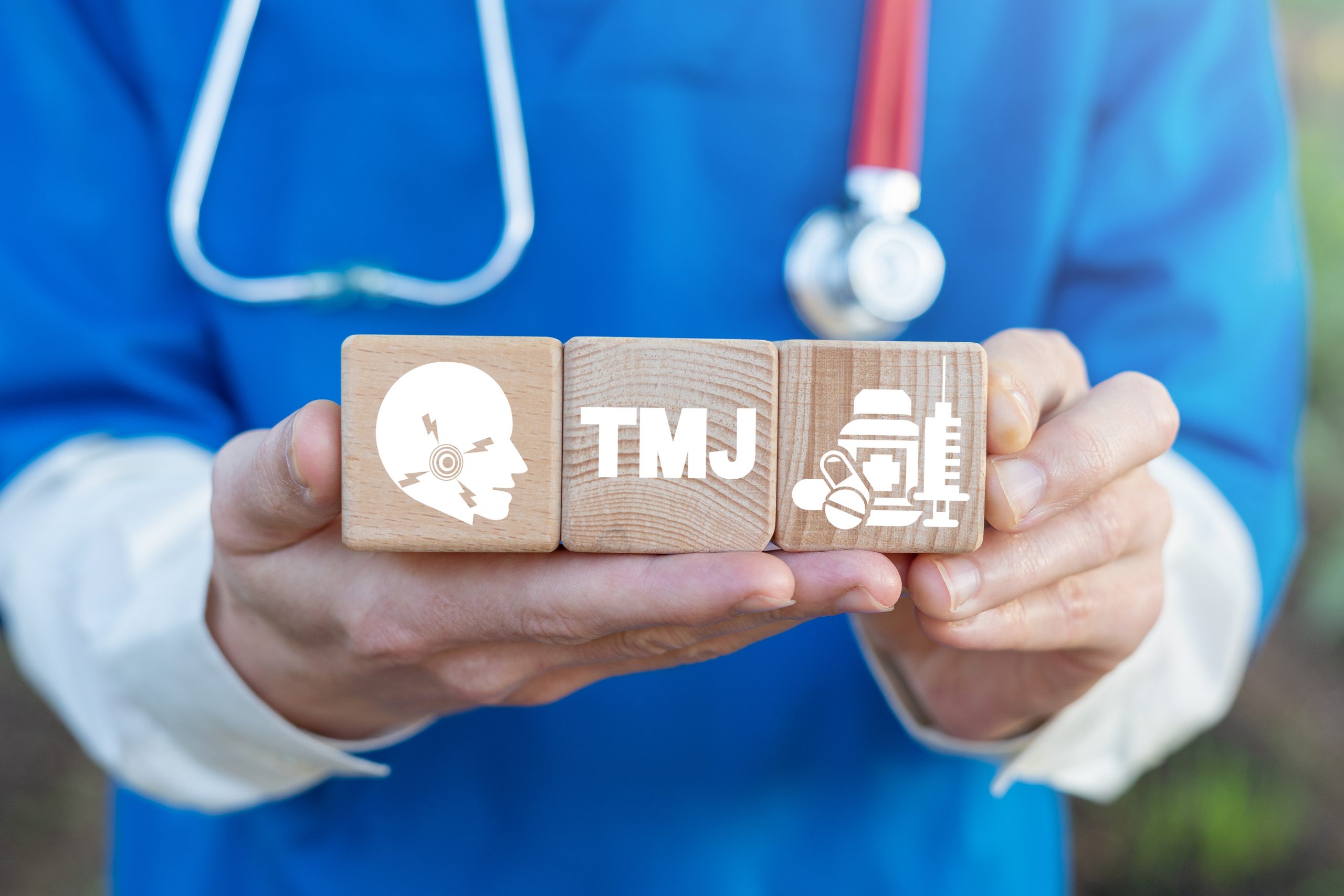 TMJ TMD health care concept on wooden blocks in doctor hands. Temporomandibular Joint and Muscle Disorder Medicine.